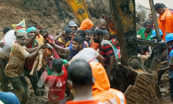 കൊക്കയാര്‍ ഉരുപൊട്ടലില്‍ കാണാതായ കുട്ടികളില്‍ ഒരാളുടെ മൃത​ദേഹം രക്ഷാപ്രവര്‍ത്തകര്‍ പുറത്തെടുക്കുന്നു. ഫോട്ടോ: ഏയ്ഞ്ചല്‍ അടിമാലി