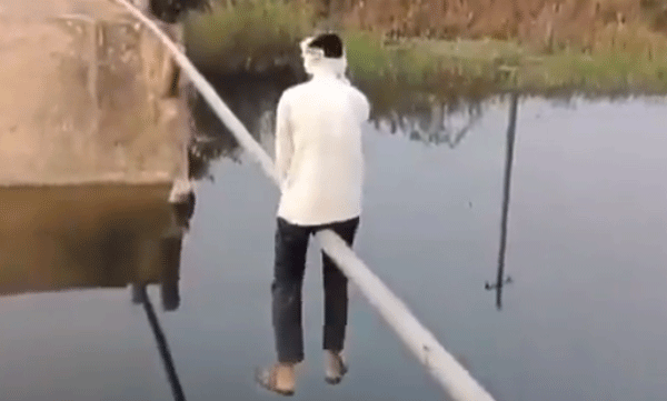 പാലം തകര്‍ന്നു: ഇരുമ്പുപൈപ്പിലിരുന്ന് പുഴ കടക്കുന്ന മനുഷ്യന്‍, വൈറലായി വീഡിയോ 
