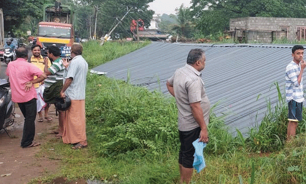 വീശിയടിച്ച കാറ്റില് വ്യാപാര സ്ഥാപനത്തിന്റെ മേല്ക്കൂര പറന്നുപോയി ; െഹെവേയ്ക്ക് മുകളിലൂടെ മറുവശത്ത് വന്നു വീണു ; അപകടം ഒഴിവായത് തലനാരിഴയ്ക്ക്, വാഹനം വരാഞ്ഞതിനാല് രക്ഷപ്പെട്ടു